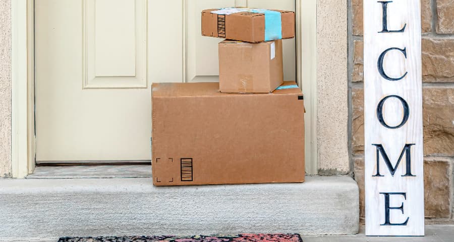 Packages on the doorstep of a home with a welcome sign in Saginaw